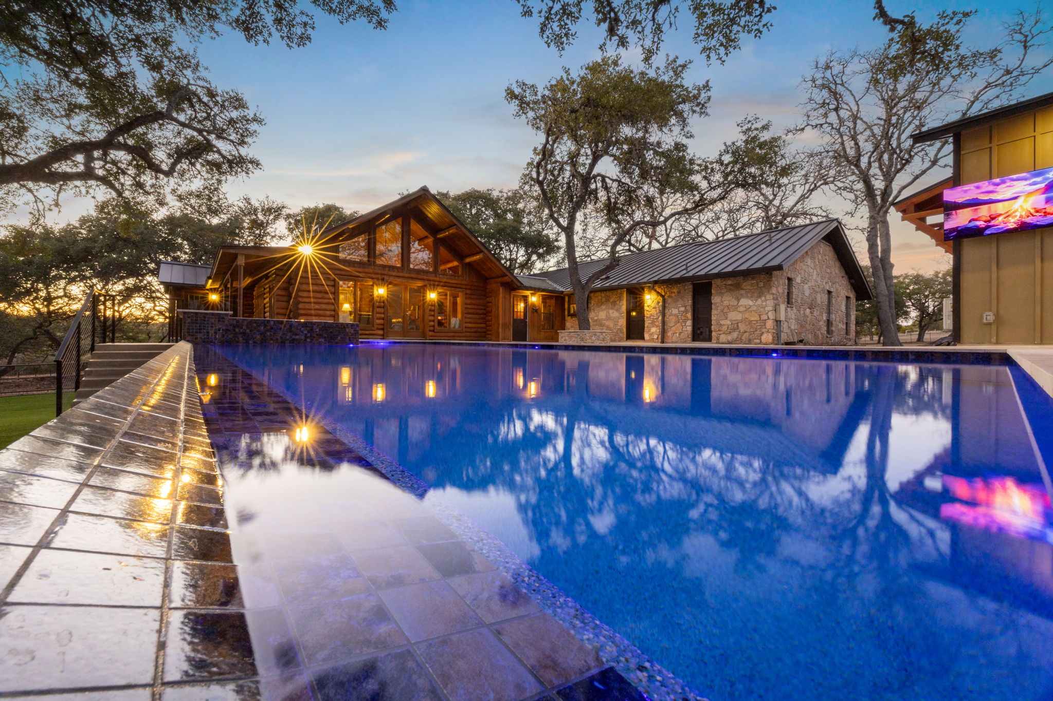 Pool with fire features and ambient twilight lighting