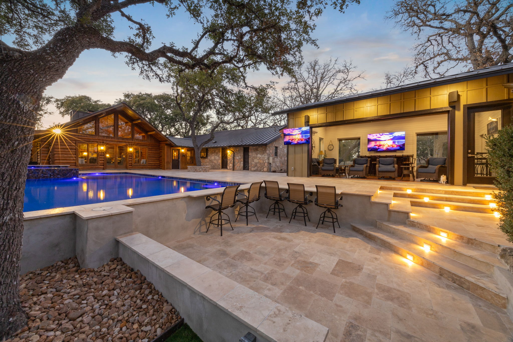 Twilight pool with warm glow and fire bowls